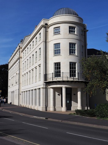 Modern building in Georgian style featuring columns, sash windows, parapets and small dome