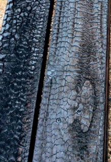 Close-up of the charred planks' surface, with its scaly, lustrous finish