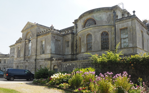 Exterior of New Wardour Castle with colourful flower bed in bloom in foreground